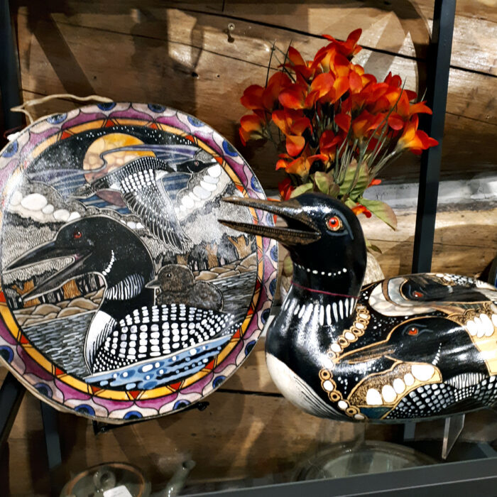 Wooden loon and hide drum by John Doherty, both with inked loon designs.